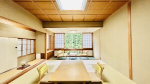 Camera in stile tatami con tavolo basso e sedie vicino alla finestra