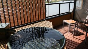 Bain extérieur privé rond sur un balcon avec claustra