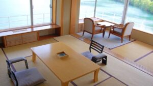 Tatami-Zimmer mit niedrigem Tisch und Stühlen am Fenster