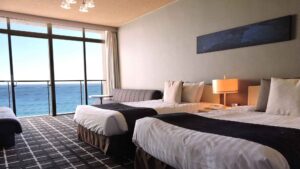 바다 전망 발코니를 향한 게스트룸의 트윈 베드