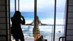 객실에서 바다를 내려다보는 창가에 선 여성들