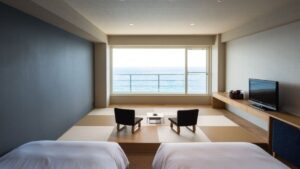 Camera in tatami con sedie basse davanti a una finestra sull’oceano