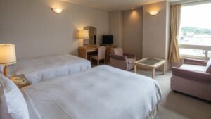 Letti singoli in una camera con sedie e scrivania