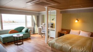 Chambre avec lit, canapé, bureau et fenêtre