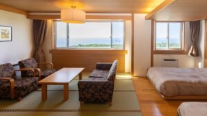 Chambre avec lits, coin salon et vue sur l’océan