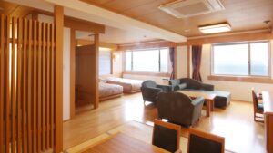 Chambre avec coin salon avec canapé et lits