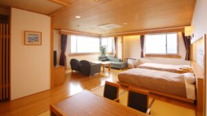Chambre avec lits jumeaux et coin salon avec canapé