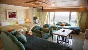 Chambre avec lits jumeaux, fauteuils et vue par la fenêtre