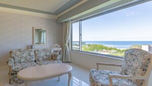 Vue sur l’océan depuis la chambre avec canapé et chaises