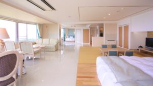 Chambre spacieuse avec lits, coin salon avec canapé et fenêtres