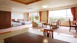 Chambre spacieuse en tatami avec lits, chaises et table