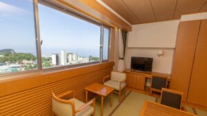 Coin salon d’une chambre en tatami avec chaises, table et fenêtre