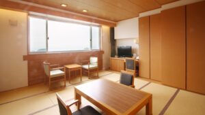 Chambre en tatami avec table basse, chaises et télévision