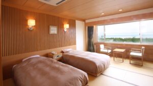 Lits jumeaux dans une chambre d’hôtes en tatami près de la fenêtre