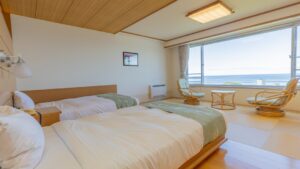 Lits jumeaux dans une chambre en tatami avec banquette près de la fenêtre