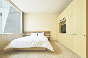 Chambre minimaliste avec grand lit et télévision murale