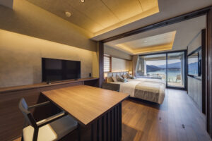 Dormitorio con mesa, sillas y dos camas junto a la ventana
