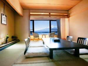 Habitación de tatami con mesa baja y sillas junto a la ventana