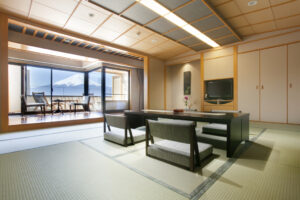 Habitación de tatami con mesa baja y sillas junto a la ventana