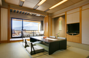 Habitación de tatami con mesa baja y vistas a la montaña