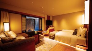 ベッド、ソファ、デスク、窓のある客室