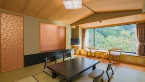 Chambre en tatami avec table basse et banquette près de la fenêtre