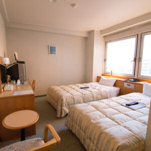 Twin beds beside a window in a guest room