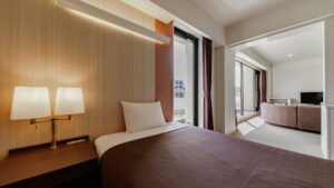 Bed in guest room with lamps and seating area