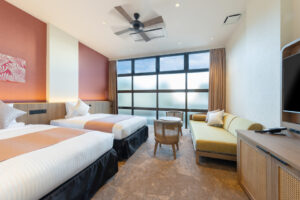 Twin beds in a guest room with sofa