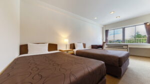Two beds in a guest room with window