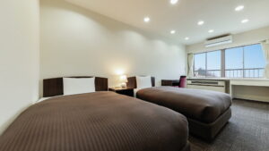 Two beds in a guest room with window