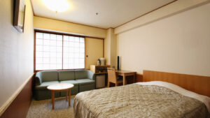 Bett mit Sofa, Tisch und Schreibtisch im Gästezimmer