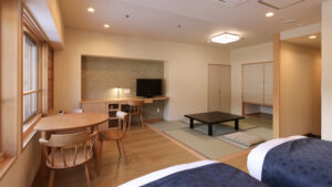 Gästezimmer mit Tisch, Stühlen und Tatami-Sitzbereich