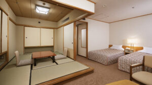 Gästezimmer mit zwei Einzelbetten und Tatami-Sitzbereich