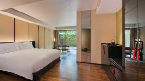 Schlafzimmer mit großem Bett und Sitzgelegenheit am Fenster