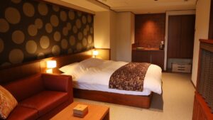 Lit et canapé dans une chambre d’hôtes à l’éclairage chaleureux