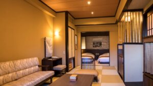 Chambre de style tatami avec canapé, table et lits