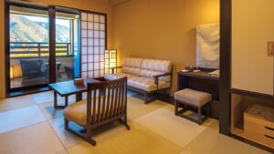 Chambre en tatami avec chaises, canapé et vue depuis le balcon