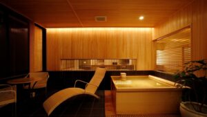 Private wooden bath with lounge chairs in guest room