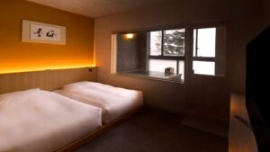 Two low beds beside a window in a guest room