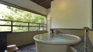 带森林景观的大窗旁的圆形客房内浴池