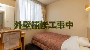 修理のお知らせテキストが重ねられたシングルベッドルーム