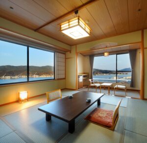 低いテーブルと港の眺めがある畳の部屋
