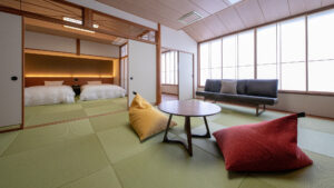Chambre en tatami avec table basse, coussins, canapé et lits