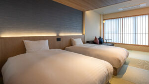 Deux lits jumeaux dans une chambre d’hôtes avec tatami