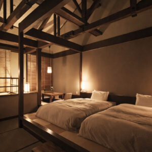 Zwei Betten in einem warm beleuchteten japanischen Gästezimmer