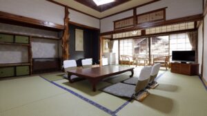 Tatamizimmer mit niedrigem Tisch, Bodensesseln und Sitzplätzen am Fenster