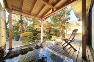 Bain privé en plein air près d’une terrasse en bois et d’une chaise