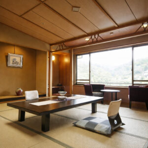 Tatami-Zimmer mit niedrigem Tisch und Sitzplätzen am Fenster