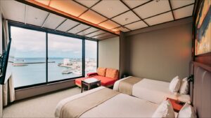 Lits jumeaux près d’une fenêtre avec vue sur l’océan